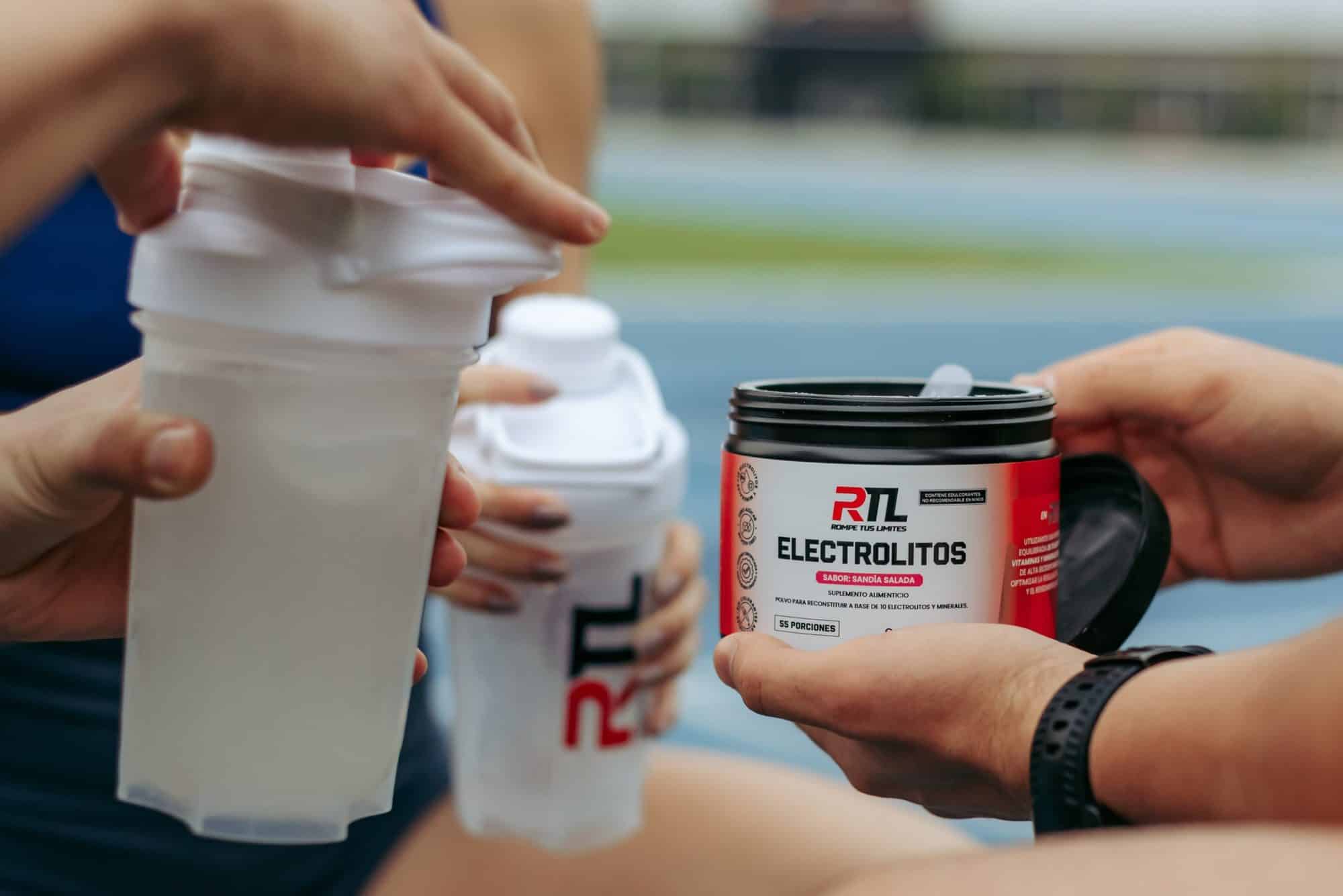 Atletas preparando bebidas en shakers con el envase de Electrolitos RTL